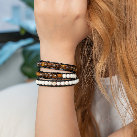 A woman wearing a triple-layer White Turquoise and Tiger’s Eye wrap bracelet with black leather cord.