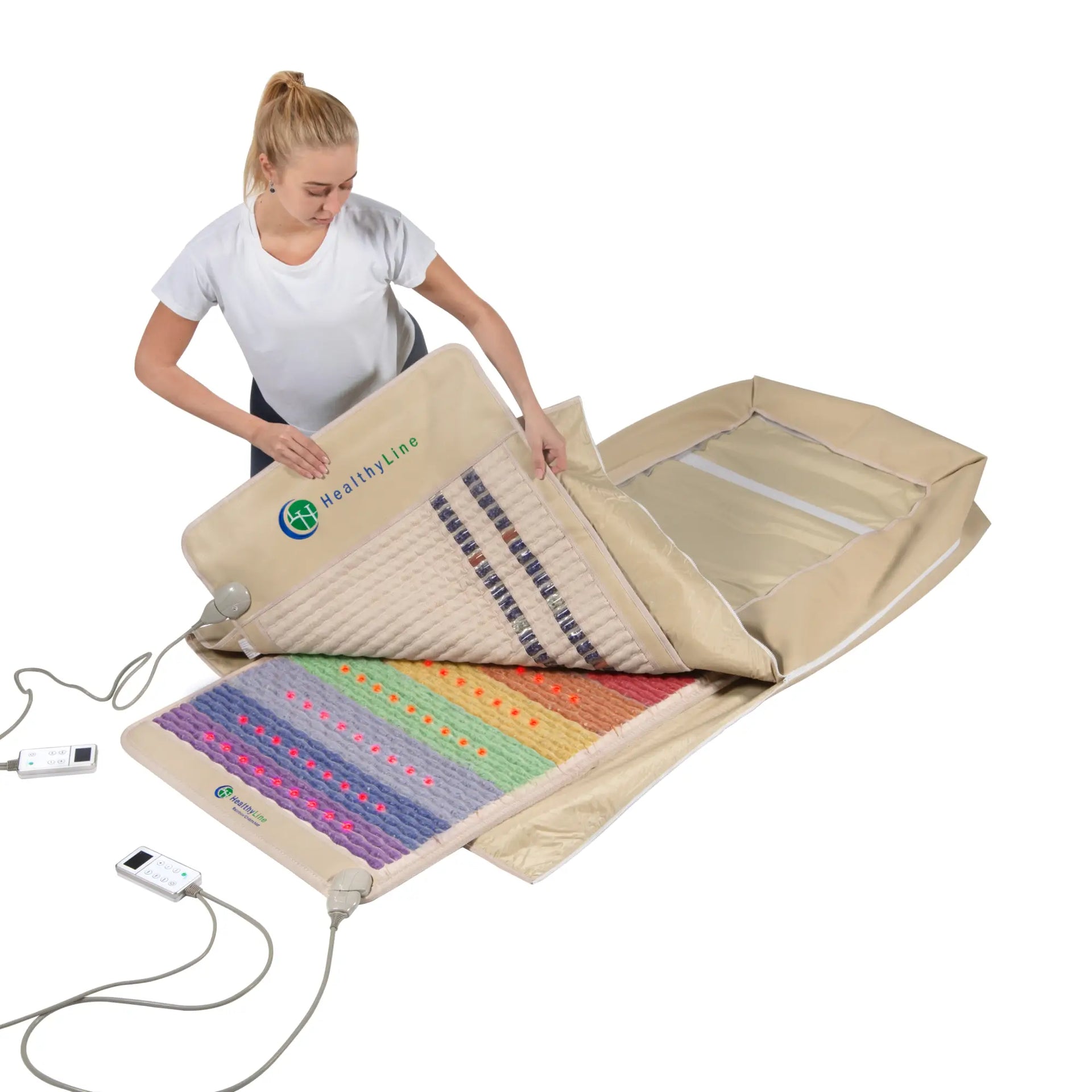Woman setting up HealthyLine 360 Wrap Set: layering tan SOFT 7428 mat over Rainbow Chakra 7428 LED mat.
