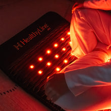 Close-up of the Jet mat with red photon lights glowing intensely in a dark red-lit environment, mat lying flat on a surface