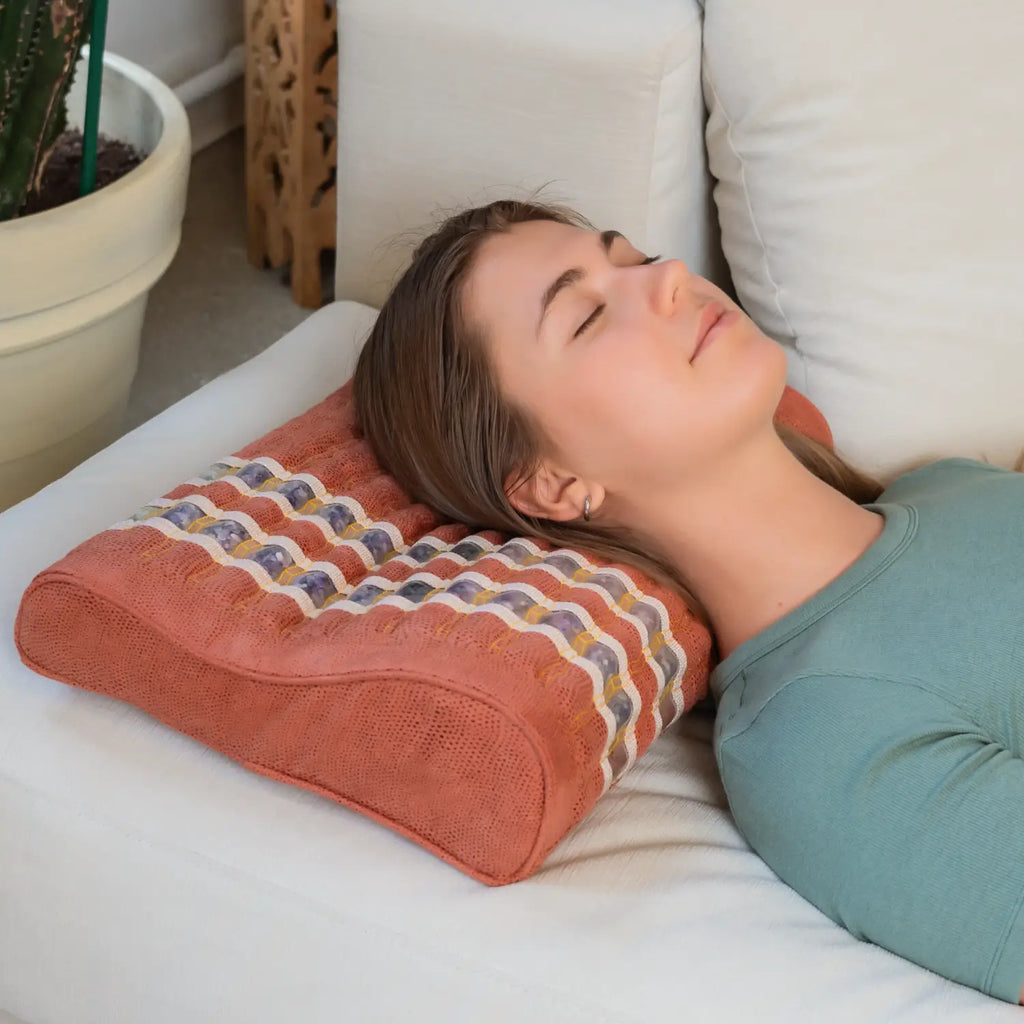 Person using TAO Pillow for neck and shoulder support, dark navy memory foam cover with gemstone therapy active