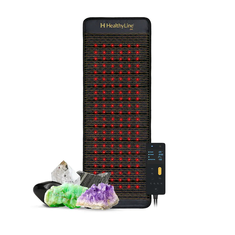 HealthyLine Jet Series 72x24 inch PEMF mat in dark fabric with grid of glowing red photon lights, shown with Gen 4 controller and natural gemstones including amethyst, jade, obsidian, and quartz crystal