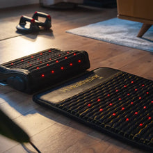 Close-up of Jet mat and pillow showing five natural gemstones embedded in dark charcoal fabric with photon light strip visible