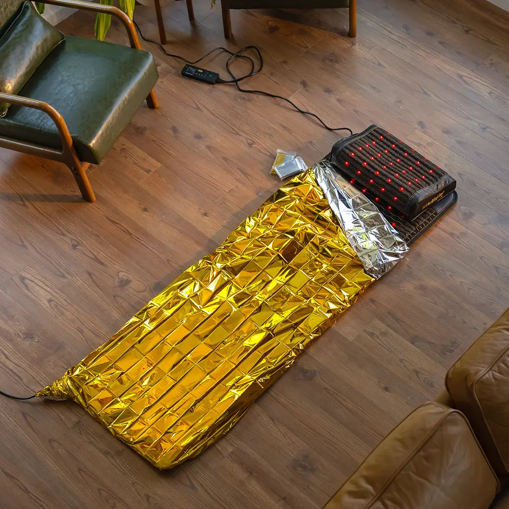 HealthyLine Jet 72x24 inch PEMF mat laid flat on the floor alongside the Jet Pillow and a gold sauna mylar blanket, showing a complete at-home therapy setup