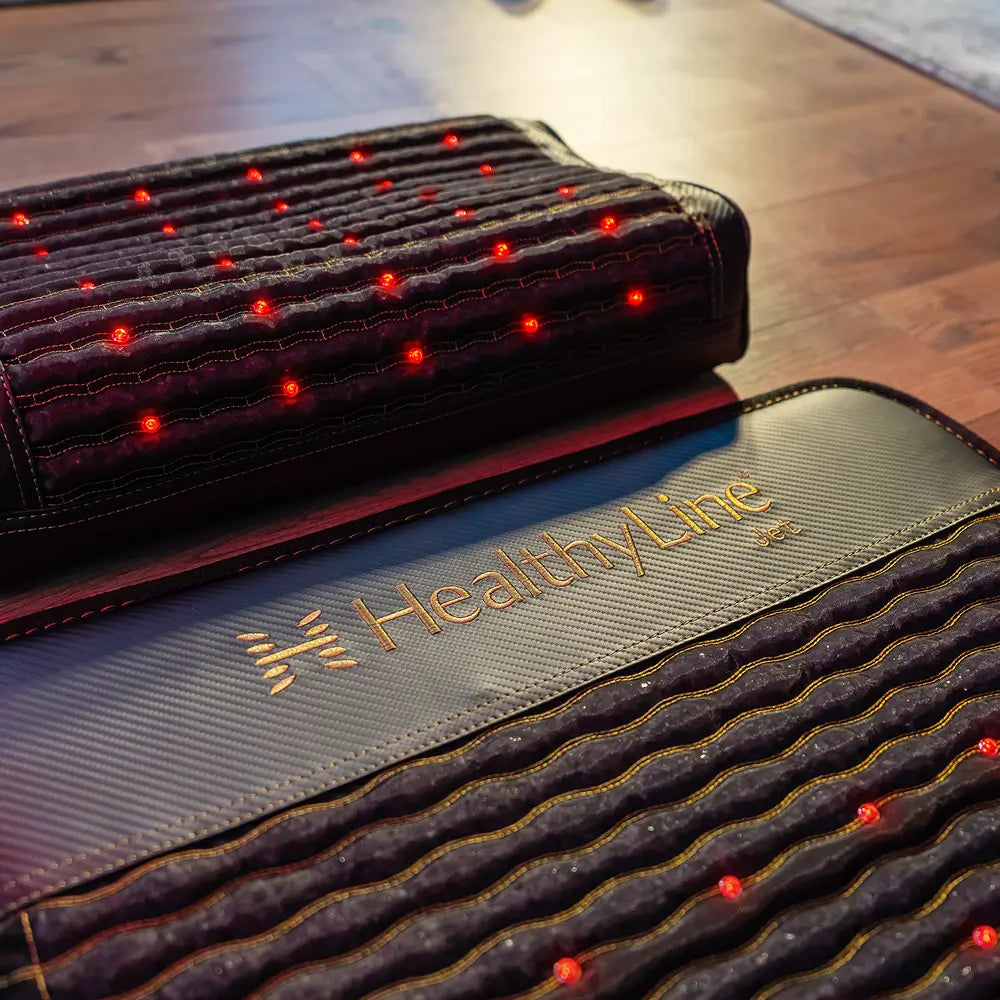 Jet Pillow close-up showing red photon lights active across dark charcoal cover surface with gemstone insert underneath