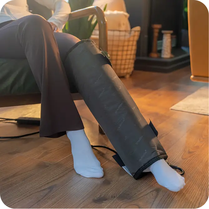 Jet mat 20x20 wrapped around a person's leg from knee to ankle while seated in a chair