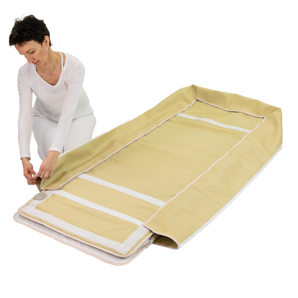 Woman assembling HealthyLine Platinum 7428 Wrap Set by layering a tan SOFT gemstone mat over a silver Platinum photon mat.
