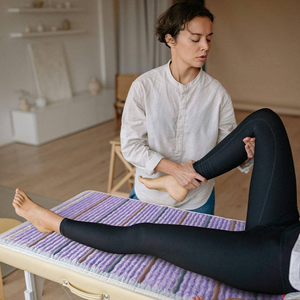 
                  
                    Patient on a Platinum 74x28 mat with silver-grey fabric, featuring glowing photon lights and a 5-gemstone therapy blend.
                  
                
