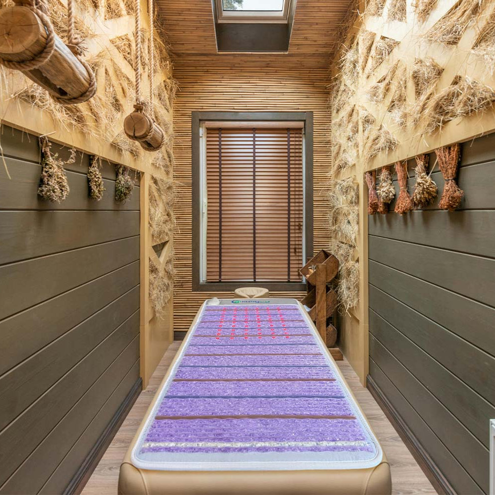 Platinum Aura 74x28 infrared mat placed on a massage table in spa environment 