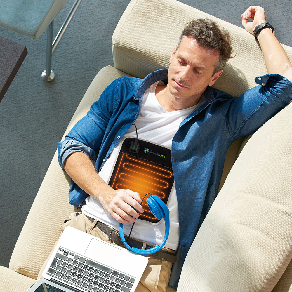 Person using Portable Heated Flat Pad on their abdomen at home
