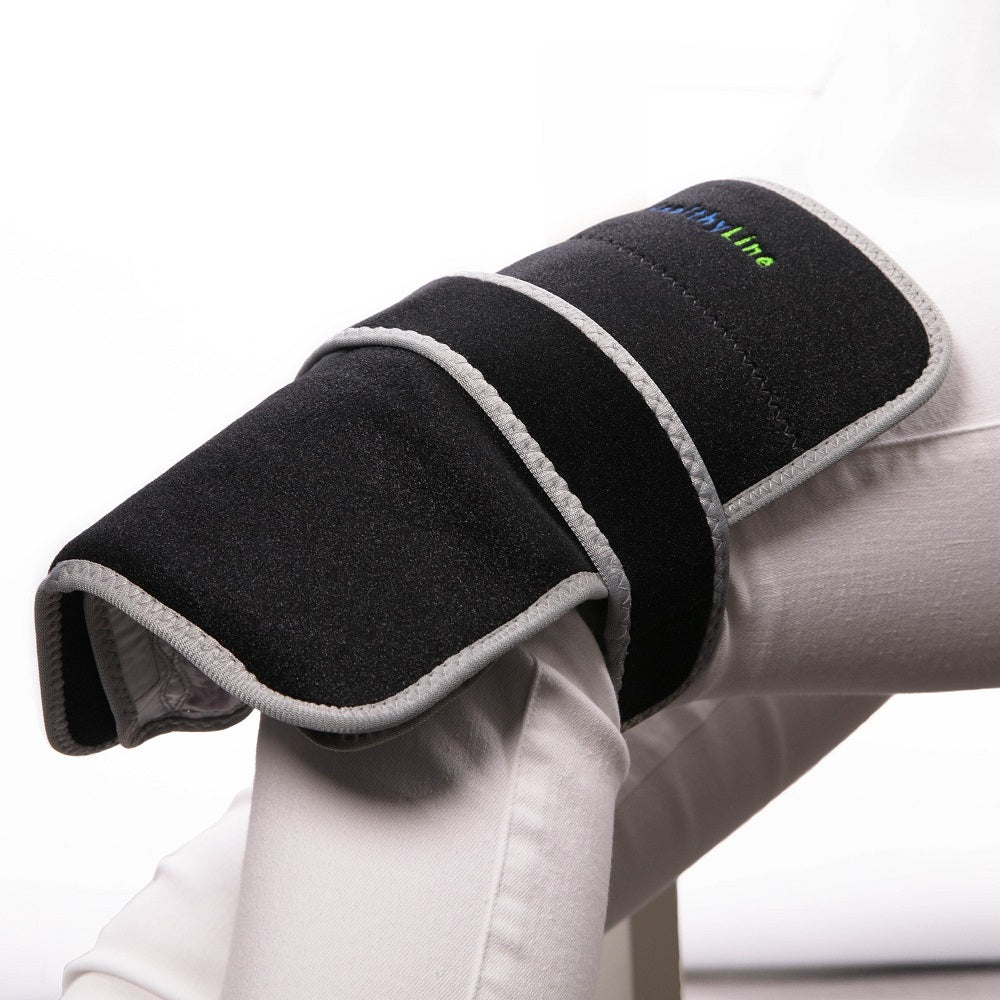 Portable Heated Gemstone Pad Flat Model  by HealthyLine in use on a knee on white background 
