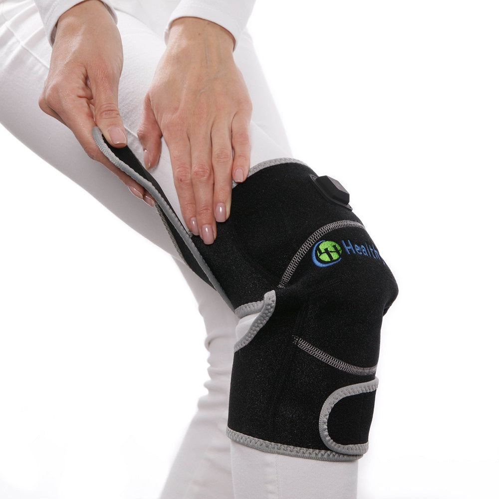 Person showing how to use Portable Heated Knee Pad by wrapping around their knee for targeted gemstone therapy and pain relief
