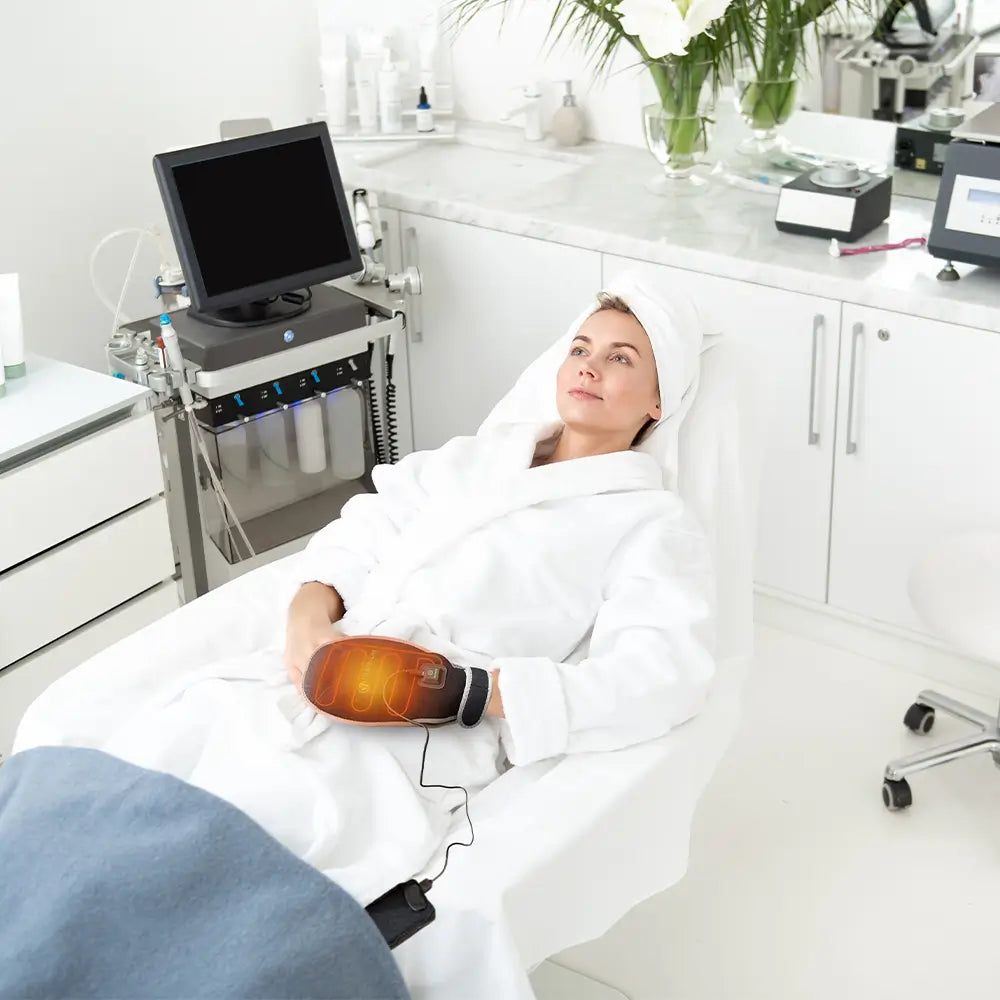 Woman in spa robe wearing a HealthyLine heat therapy hand mitt during treatment.
