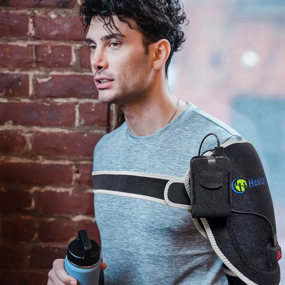 Man on football field wearing a HealthyLine portable heat therapy shoulder wrap
