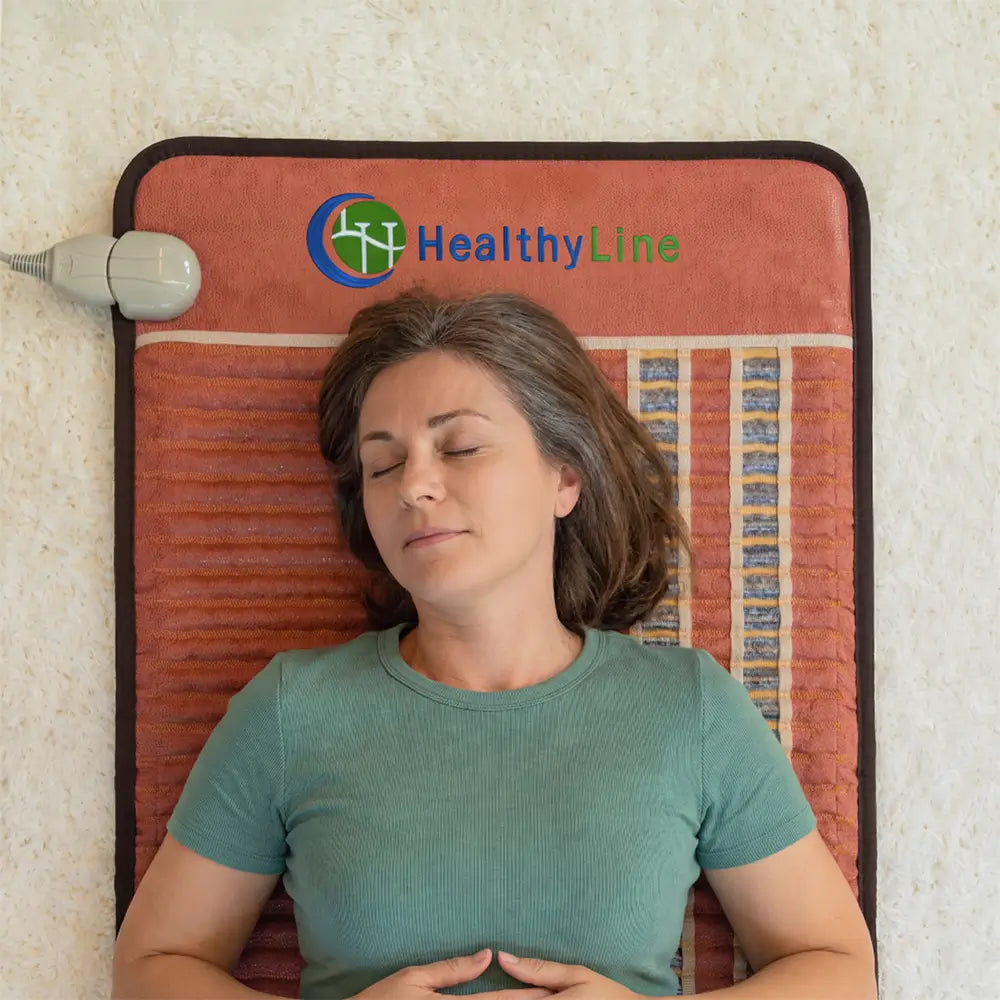 Overhead view of a woman resting with eyes closed on the red HealthyLine TAO Mat 7224
