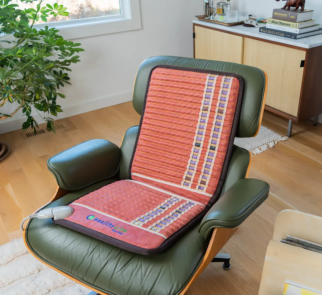 HealthyLine TAO Chair Mat 4018 draped over a green leather lounge chair in a bright living room