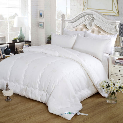 A white HealthyLine Magnetic Energy Comforter with a cotton shell on a bed, featuring natural cashmere and tourmaline.