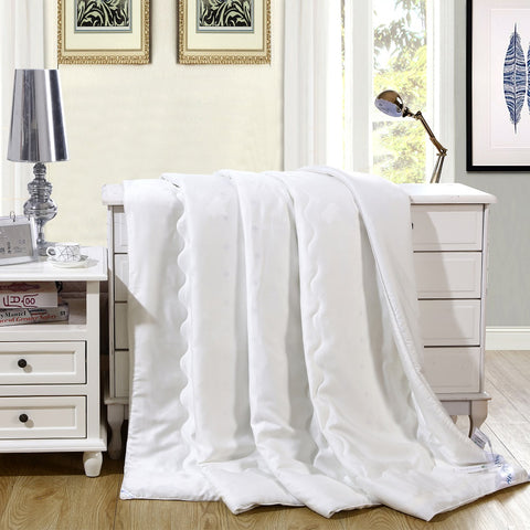 A white HealthyLine Magnetic Energy Comforter draped over a white dresser, showing its thick, quilted design.