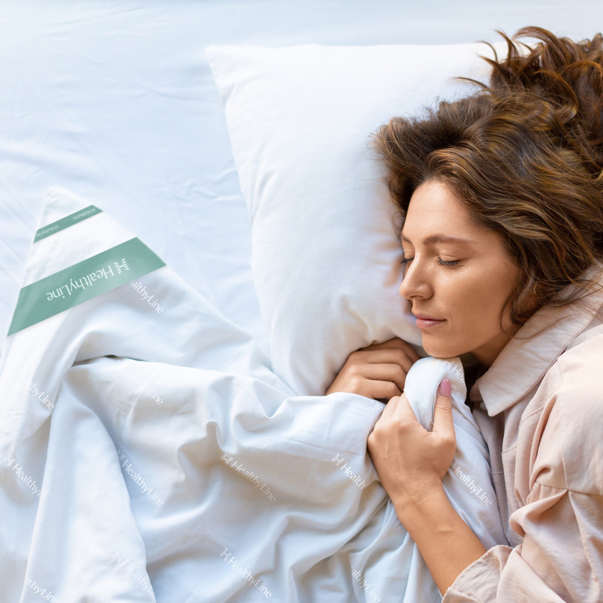 A woman sleeps under a HealthyLine silk hematite comforter
