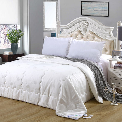 A white HealthyLine Magnetic Energy Comforter with a cotton shell on a bed, featuring natural silk and tourmaline.
