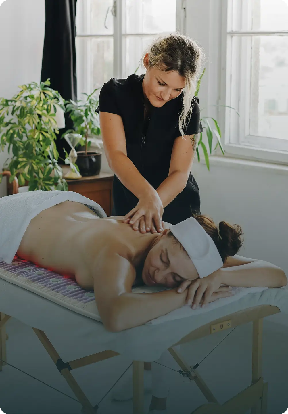 Woman receiving a back massage on the HealthyLine TAJ Mat 7428 on a massage table in a spa setting