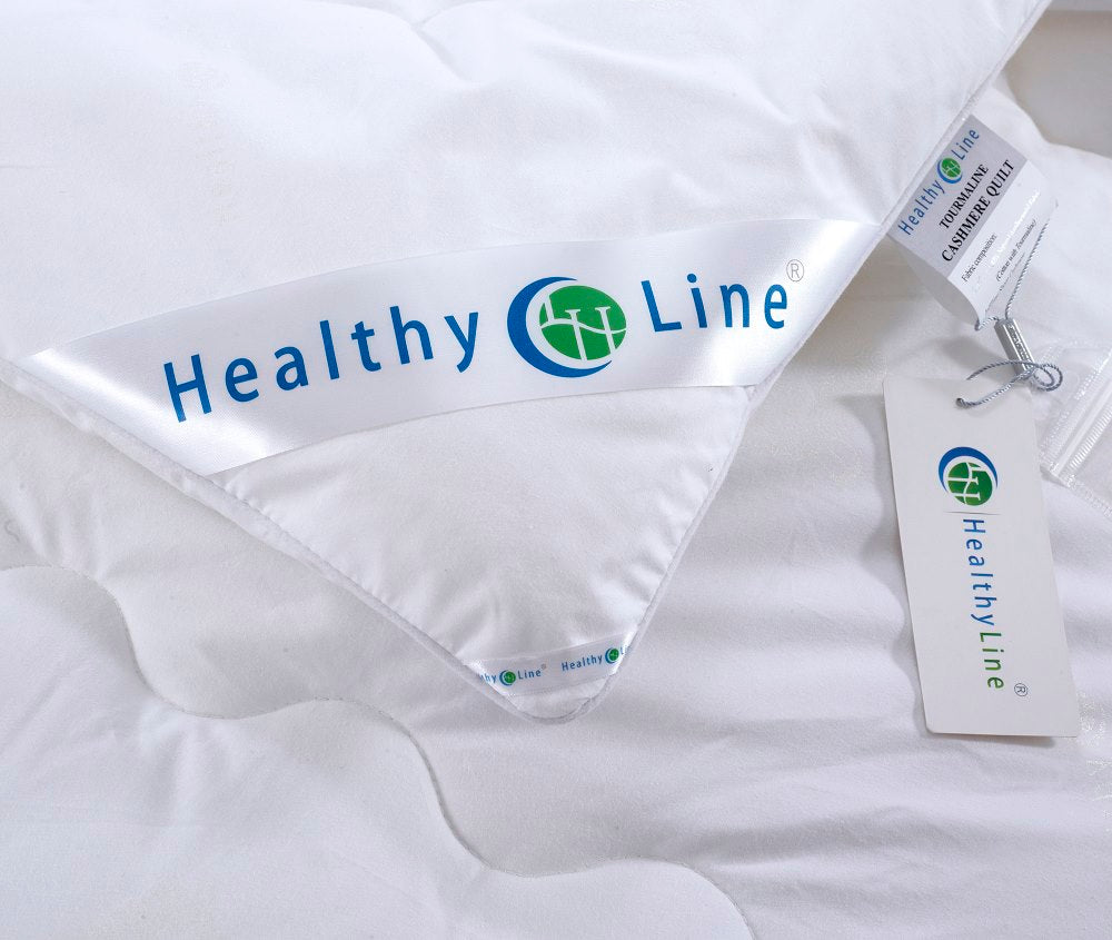 Close-up of a HealthyLine Tourmaline Cashmere Quilt featuring the brand logo and product information tags.
