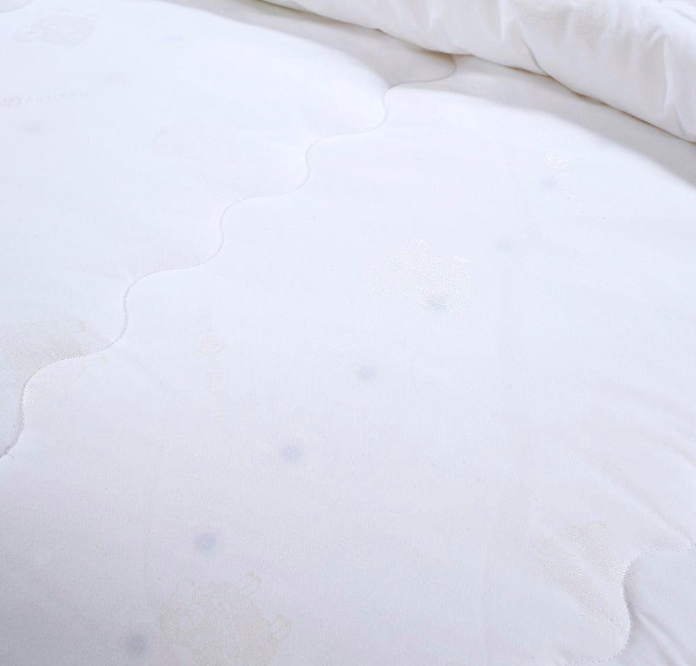Close-up of a white Magnetic Energy Comforter showing the wavy quilted stitching and smooth cotton shell texture.
