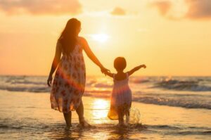 mother and daughter walking on a beach; find the best Mother’s Day gift with HealthyLine